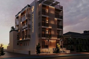 Ein mehrstöckiges Hotel mit modernem Design, mit Balkonen, einem markanten Eingang und einer gut beleuchteten Fassade.