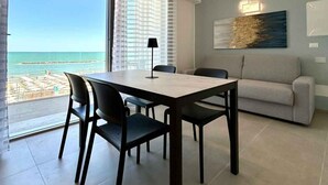 Un salon moderne avec un coin repas, un canapé et une vue sur la plage.