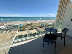 Ein Balkon mit Blick auf Strand, Pool und Stadtlandschaft.