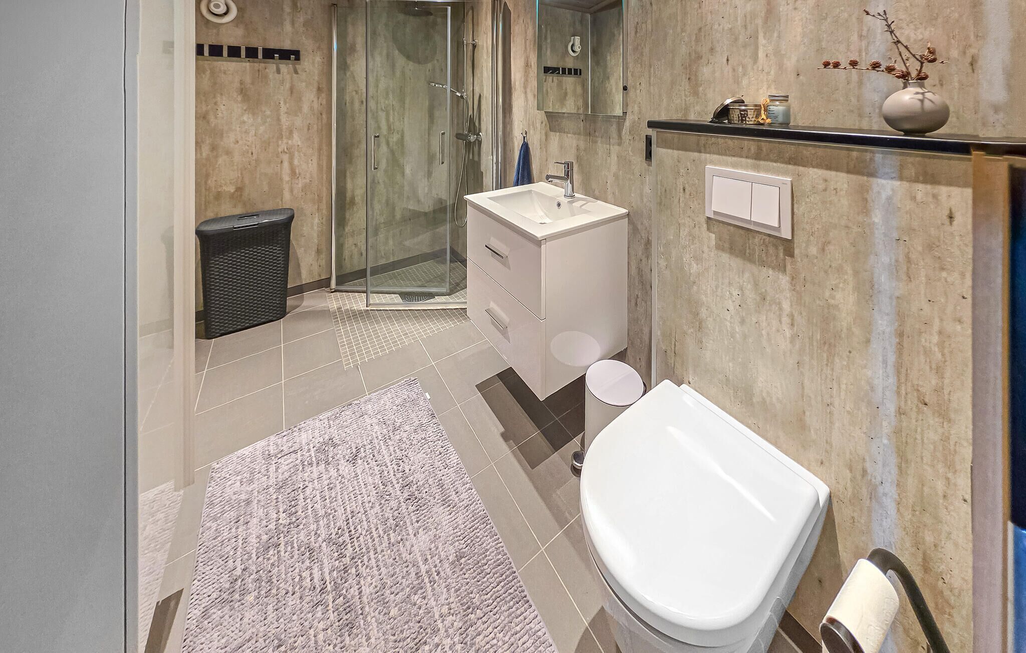 Un bagno moderno con doccia, servizi igienici e lavandino.