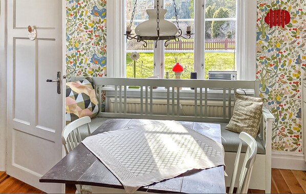 A room with a wooden bench, a table, and a window with a view of a garden. - 3 bedroom cozy home in Slite (Slite)