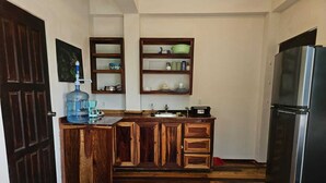 Una cocina con armarios de madera, un refrigerador de acero inoxidable y un dispensador de agua.