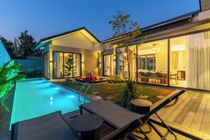 A modern house with a swimming pool, outdoor seating, and a dining area. - 3BR Retreat in Quiet Luxury Area V307 (Si Sunthon)
