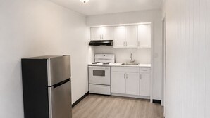 A modern kitchen with white cabinets, a stainless steel refrigerator, and a built-in oven.