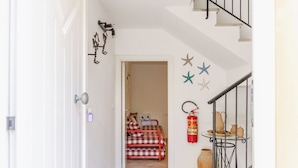 A hallway with a bed, a fire extinguisher, and a staircase. - Apartment in Fano with 2 bedrooms sleeps 5 (Fano)