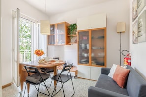 Un espacio habitable compacto con comedor, kitchenette y zona de estar.