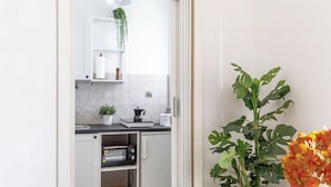 A compact kitchen with white cabinets, a microwave, a coffee maker, and a potted plant. - Apartment in Fano with 2 bedrooms sleeps 5 (Fano)