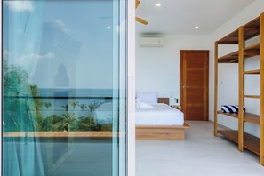 A modern bedroom with a glass wall, a wooden bed frame, and a built-in wardrobe. - SunTien, A Spectacular 4br Beach Front Pool Villa (Pha-ngan)