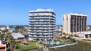 A multi-story hotel with balconies, a swimming pool, and a view of the ocean. - 3rd Coast Getaways - Aquarius 107 (South Padre Island)