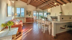 Una cocina amplia con una isla grande, vigas de madera y vistas al exterior.