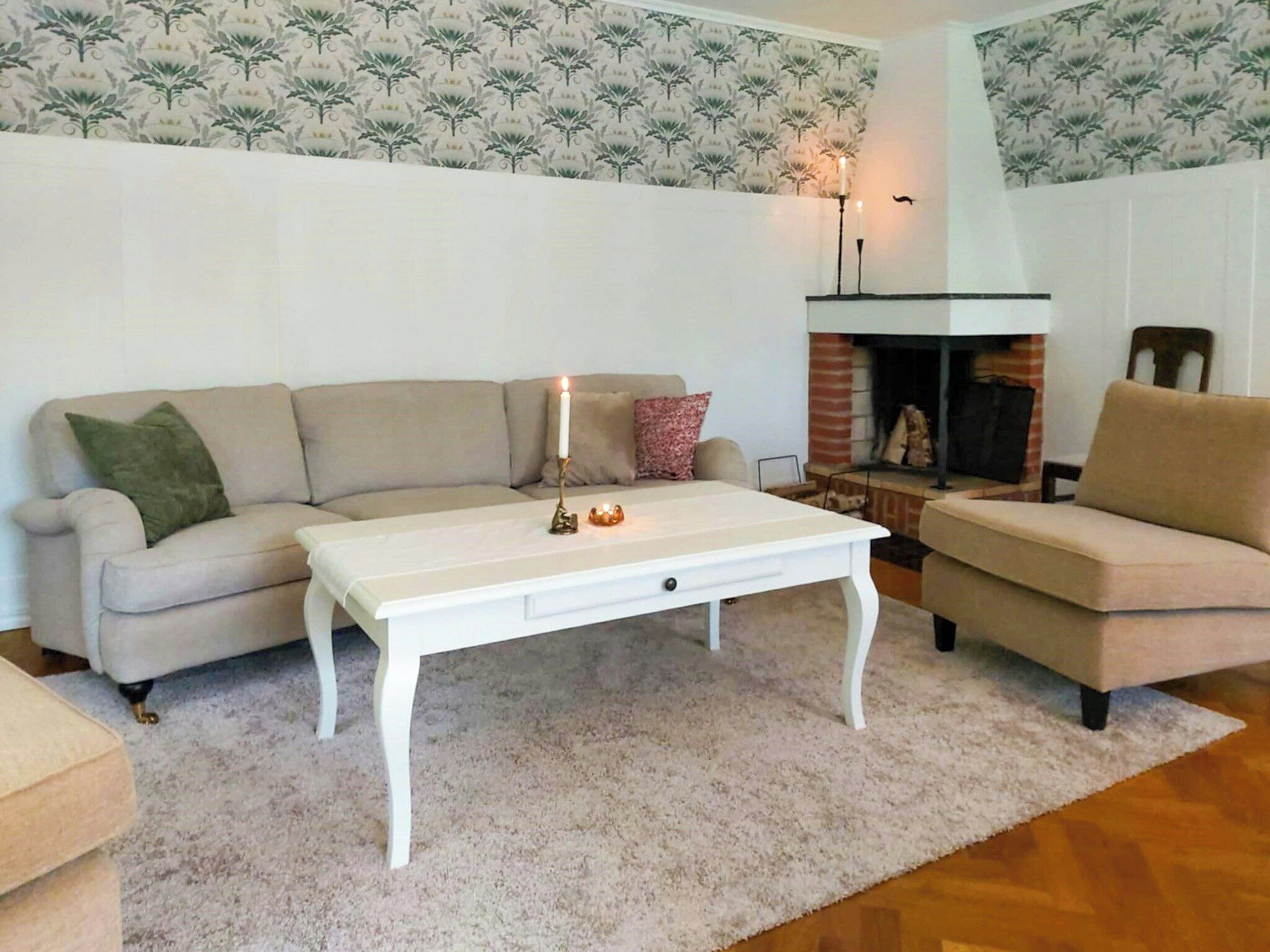 A living room with a sofa, a coffee table, and a fireplace.