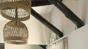 A modern living room with a white sofa, a wooden coffee table, and a hanging woven light fixture. - Villa with sea view and garden in Corsica (Porto-Vecchio)