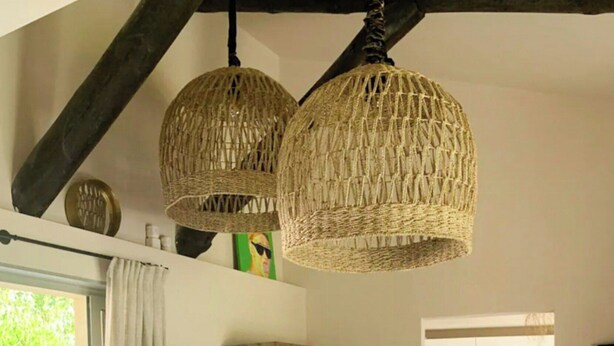 A modern living room with a sofa, a coffee table, and a hanging woven light fixture. - Villa with sea view and garden in Corsica (Porto-Vecchio)
