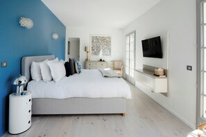 A modern bedroom with a bed, bedside table, dresser, and a TV mounted on the wall. - Villa with pool and sauna in Aix-en-Provence (Aix-en-Provence)