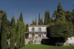 A two-story building with a stone facade, arched windows, and a balcony. - Villa with pool and sauna in Aix-en-Provence (Aix-en-Provence)