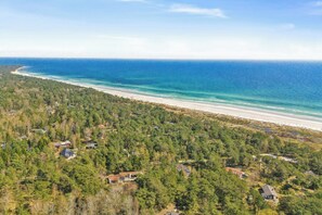 A coastal area with a beach, forested land, and scattered houses. - Renovated holiday home by forest lake in Dueodde (Nexø)