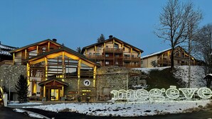 A hotel with a reception area, stone facade, and multiple balconies. - Luxury penthouse with Mont Blanc views in Megève (Megève)