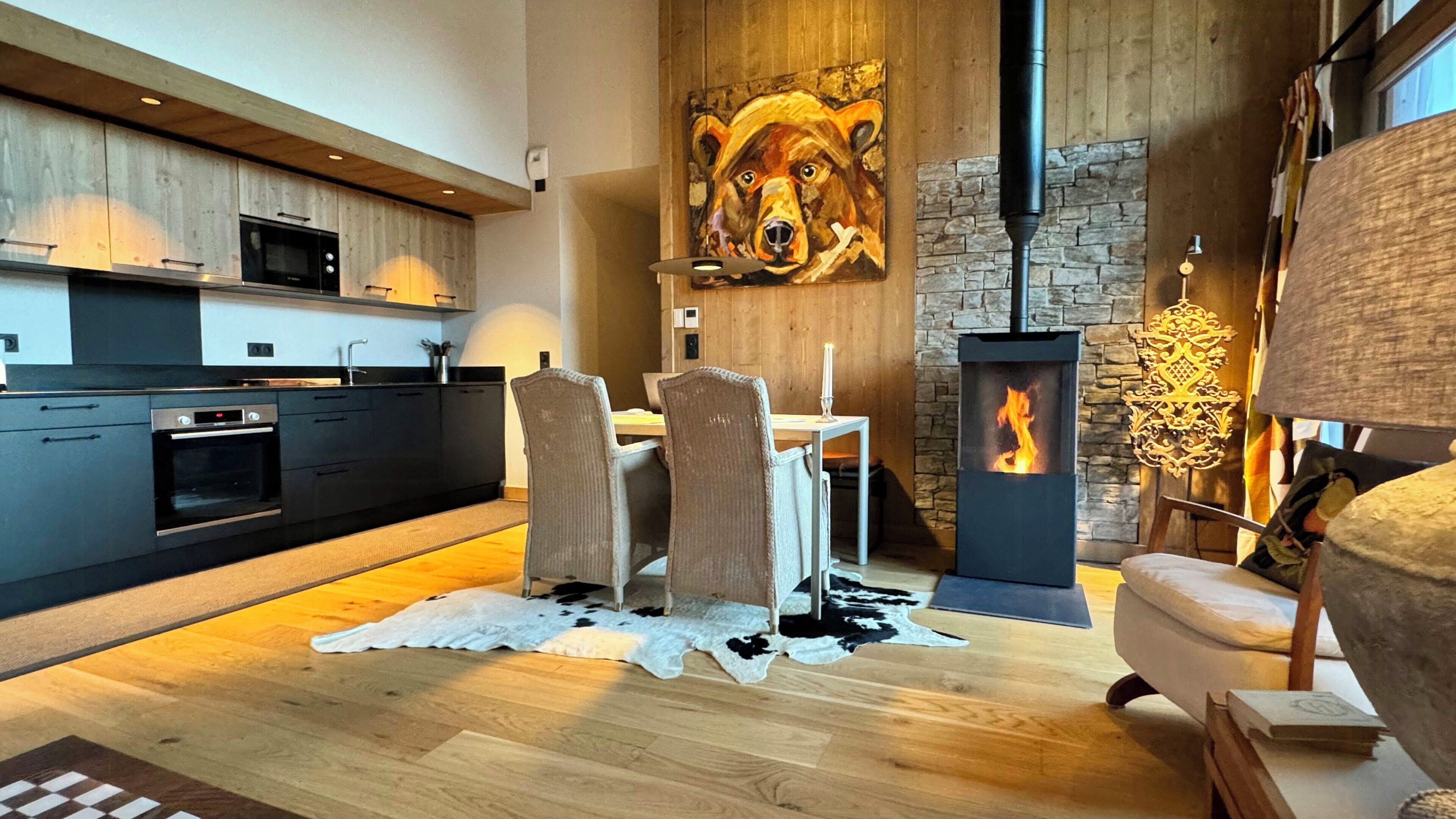Een moderne keuken met een eethoek, een open haard en een groot schilderij van een beer.