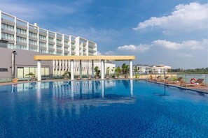 Ein Hotel mit großem Schwimmbad, überdachtem Bereich und Meerblick.