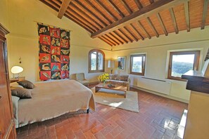 A bedroom with a bed, a sofa, a coffee table, and a large window. - Hidden villa among olive trees in Tuscany (Palaia)
