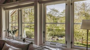 Una habitación con un ventanal grande, un sofá y una lámpara.