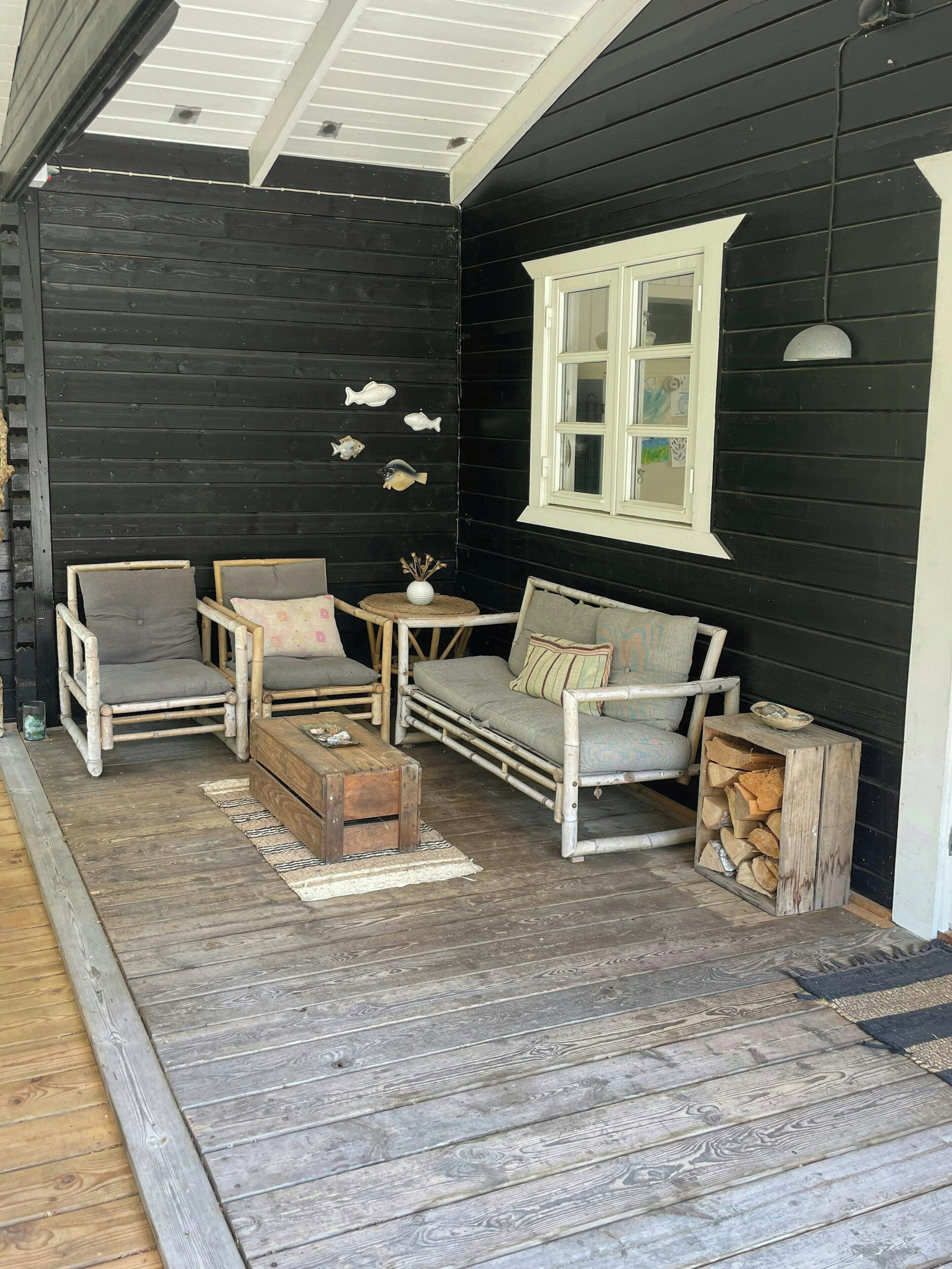 Un espace extérieur accueillant, aménagé avec un canapé, deux fauteuils et une petite table.