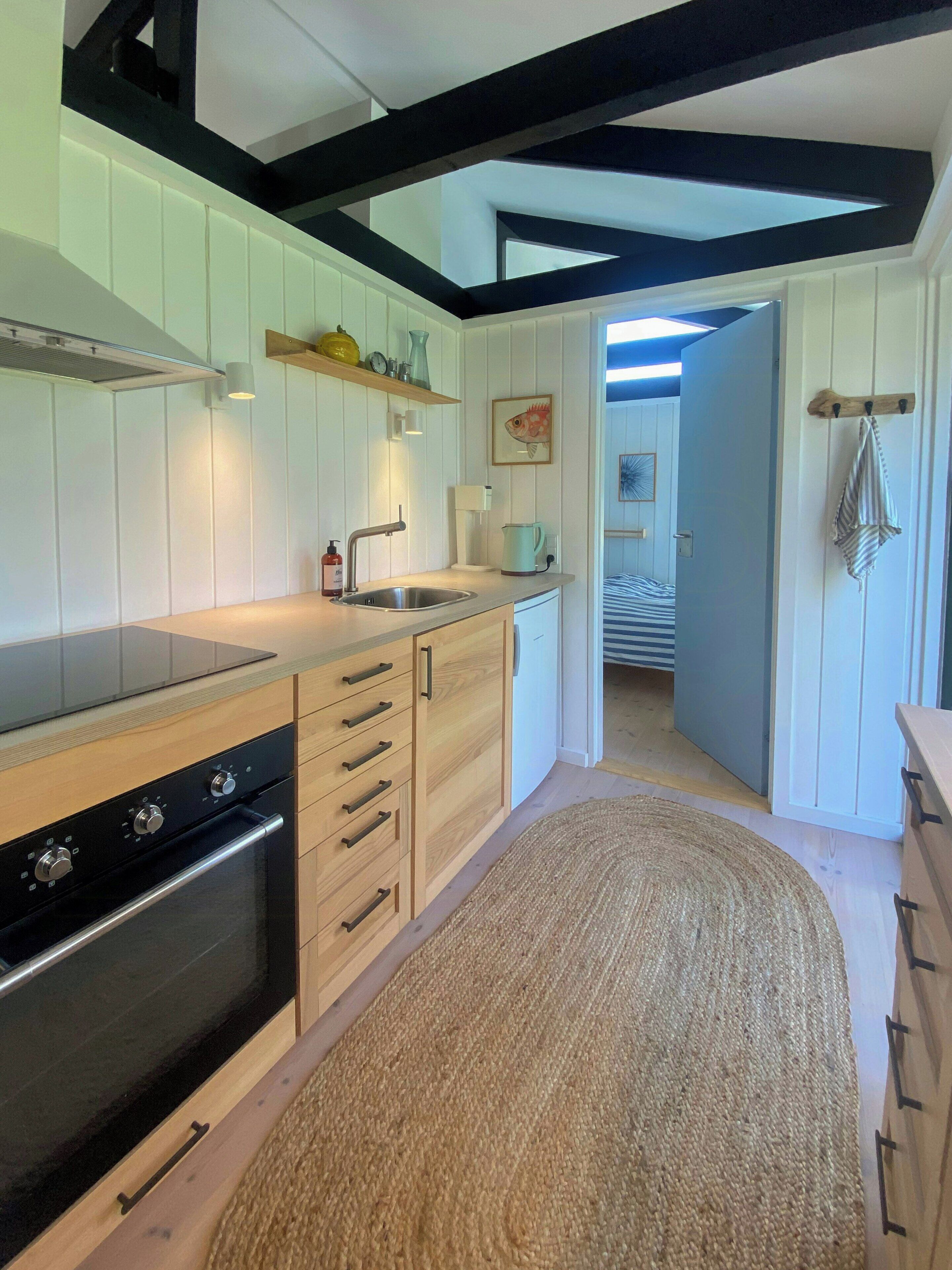 A modern kitchen with wooden cabinets, a built-in oven, and a large island.