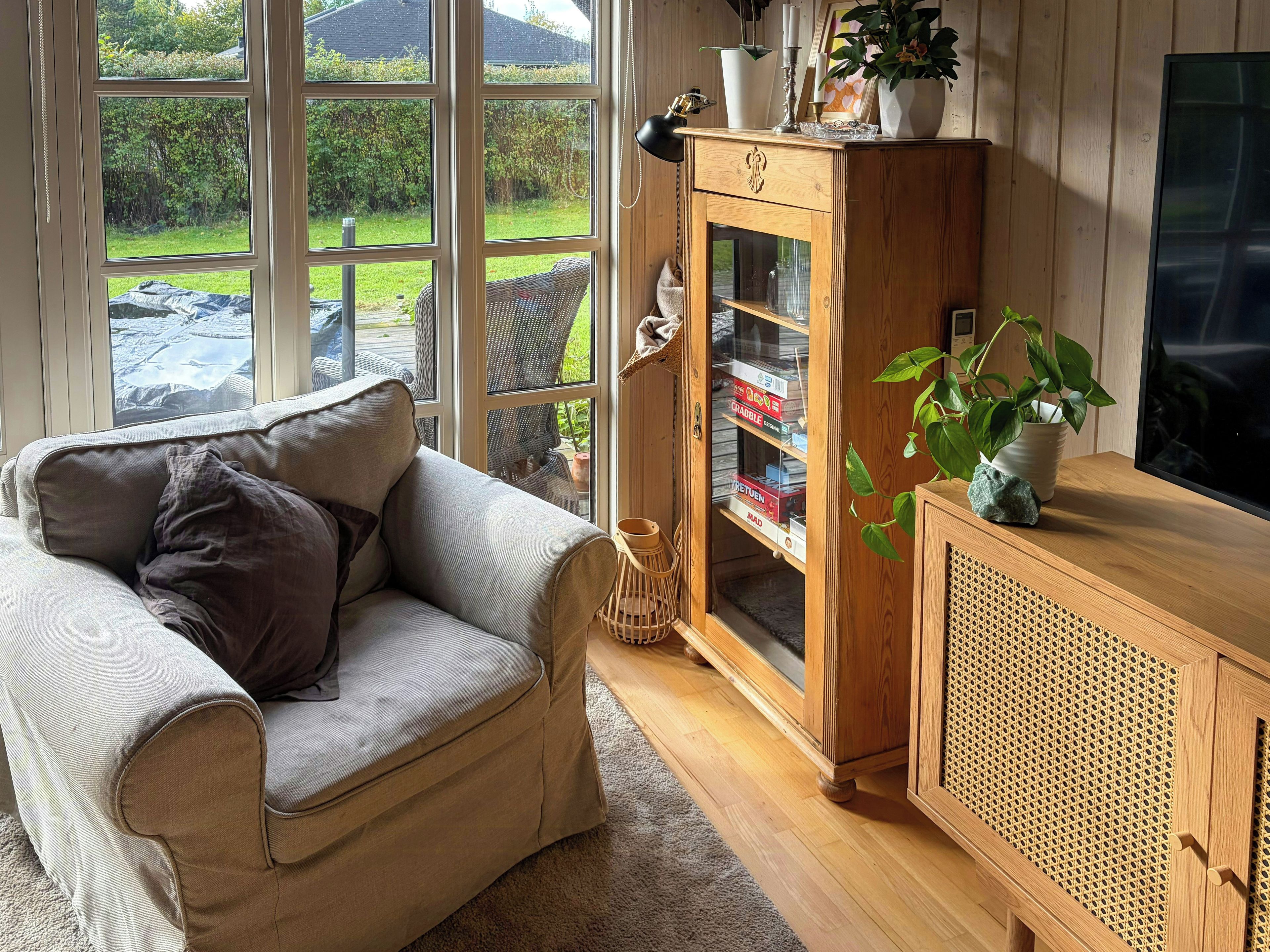 A living room with a sofa, a cabinet with glass doors, and a television.