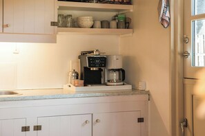 A kitchen with a coffee maker, a kettle, and a shelf with jars and books. - Thatched cottage with wildlife near Kramnitze (Dannemare)