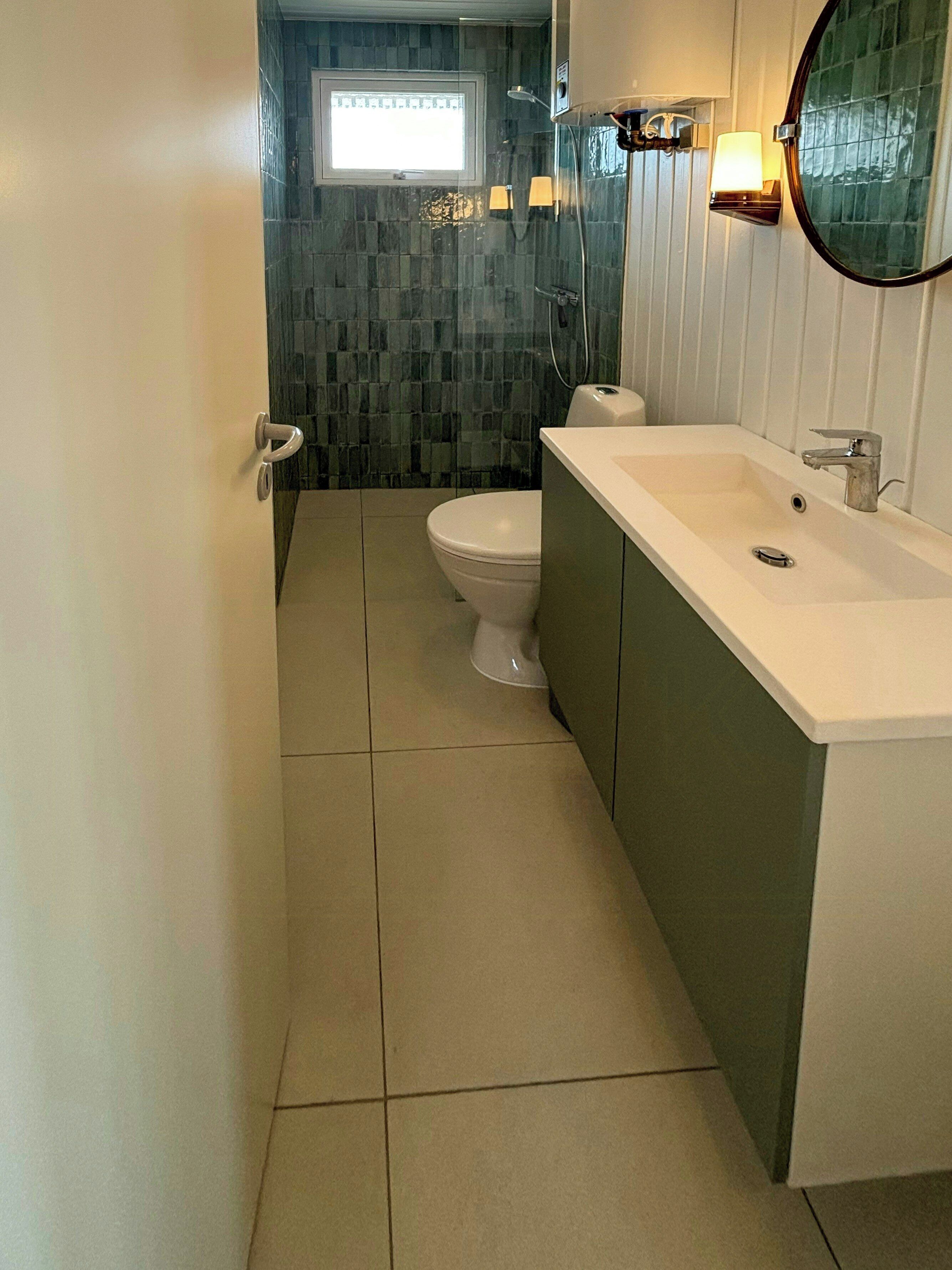 Une salle de bain avec des toilettes, un lavabo et un miroir.
