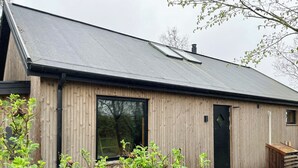 Een houten gebouw met een groot raam, een deur en een klein raam.