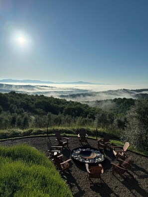 A high vantage point with a clear view of a mountainous landscape, a fire pit with seating, and a clear sky. - Historic farmhouse with infinity pool and sauna (Monte San Savino)