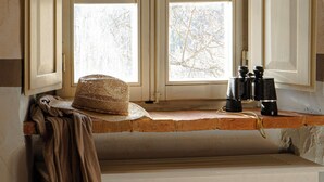 Ein Zimmer mit Fenster, Handtuch und Fernglas auf der Fensterbank.
