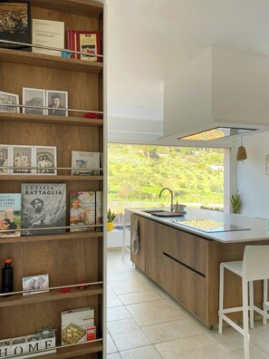 Eine moderne Küche mit Holzböden, einer zentralen Kochinsel und Blick auf Grün.