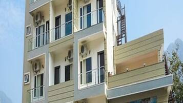 Un edificio de varios pisos con balcones, unidades de aire acondicionado y un escaparate con un letrero.