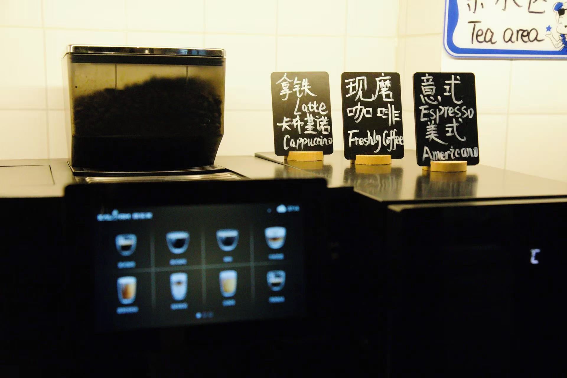 A coffee machine with a digital display and three coffee options labeled in a foreign language.