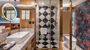A bathroom with a shower, toilet, and sink.