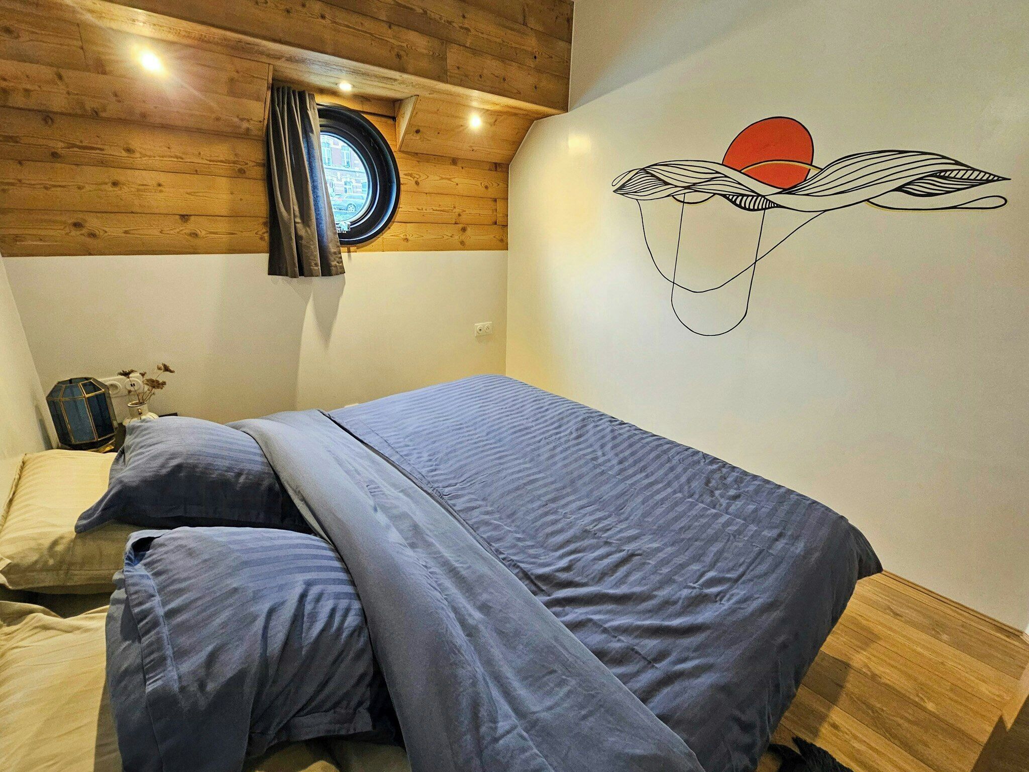 Une chambre à coucher avec un lit, une fenêtre et un élément décoratif mural.