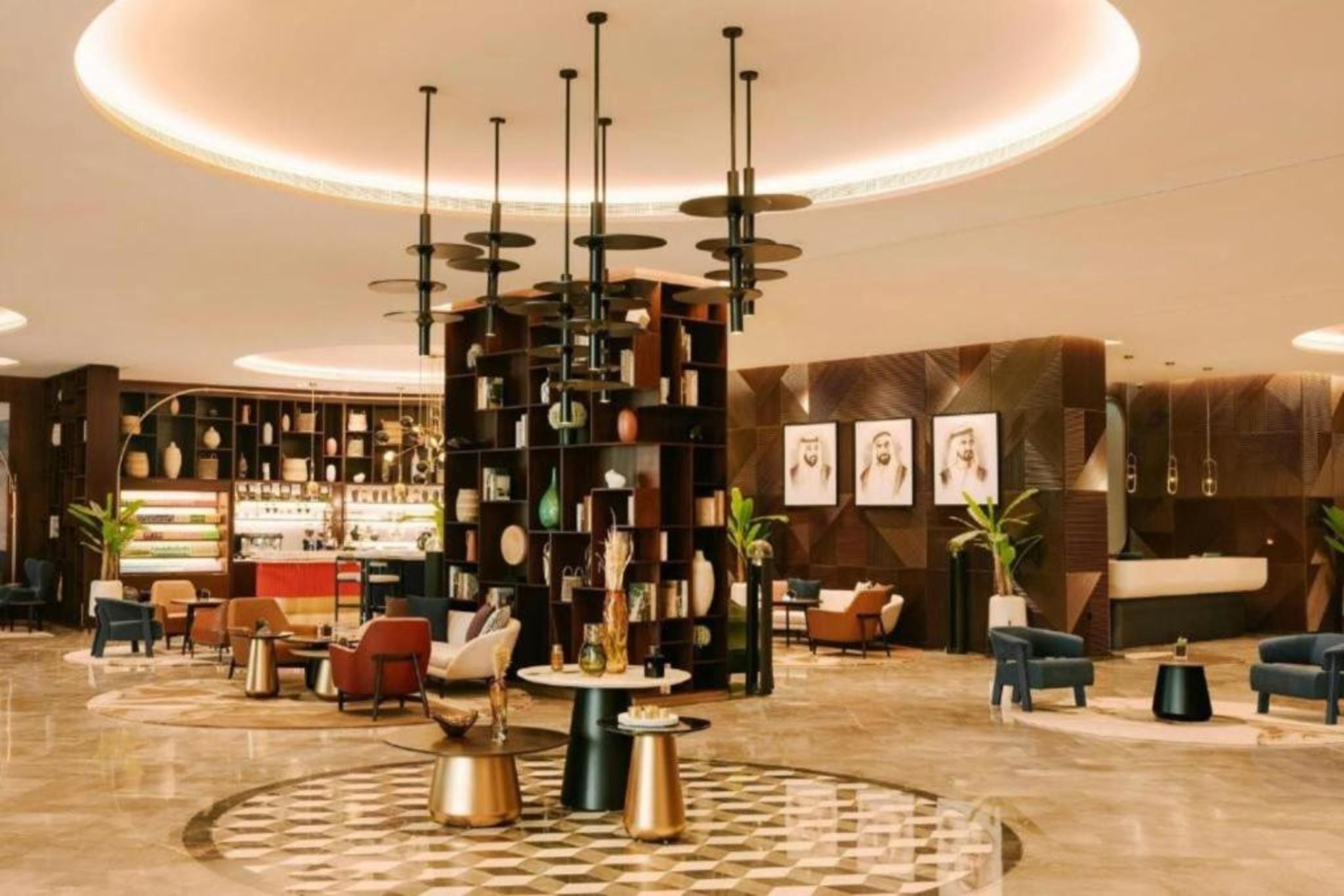 A modern lobby with a central coffee table, seating area, and a reception desk.