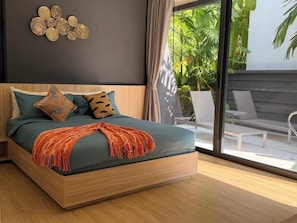 Un dormitorio moderno con una cama grande, vistas al exterior y un adorno decorativo en la pared.