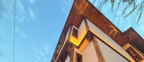 A corner of a building with a stone facade and wooden beams.