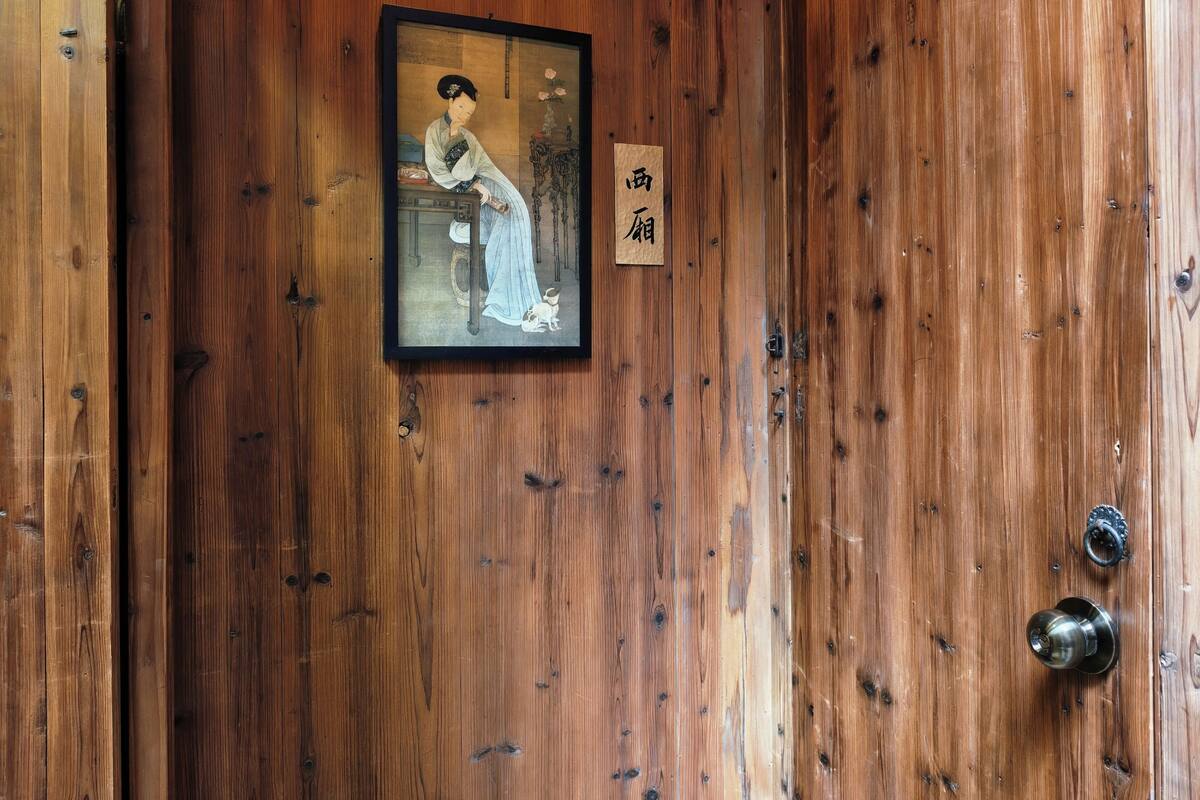 Una puerta de madera con un cuadro enmarcado y un letrero pequeño.
