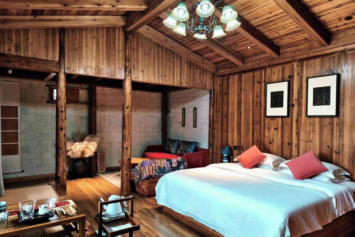 Un interior de madera con cama, zona de estar y una mesa de comedor.
