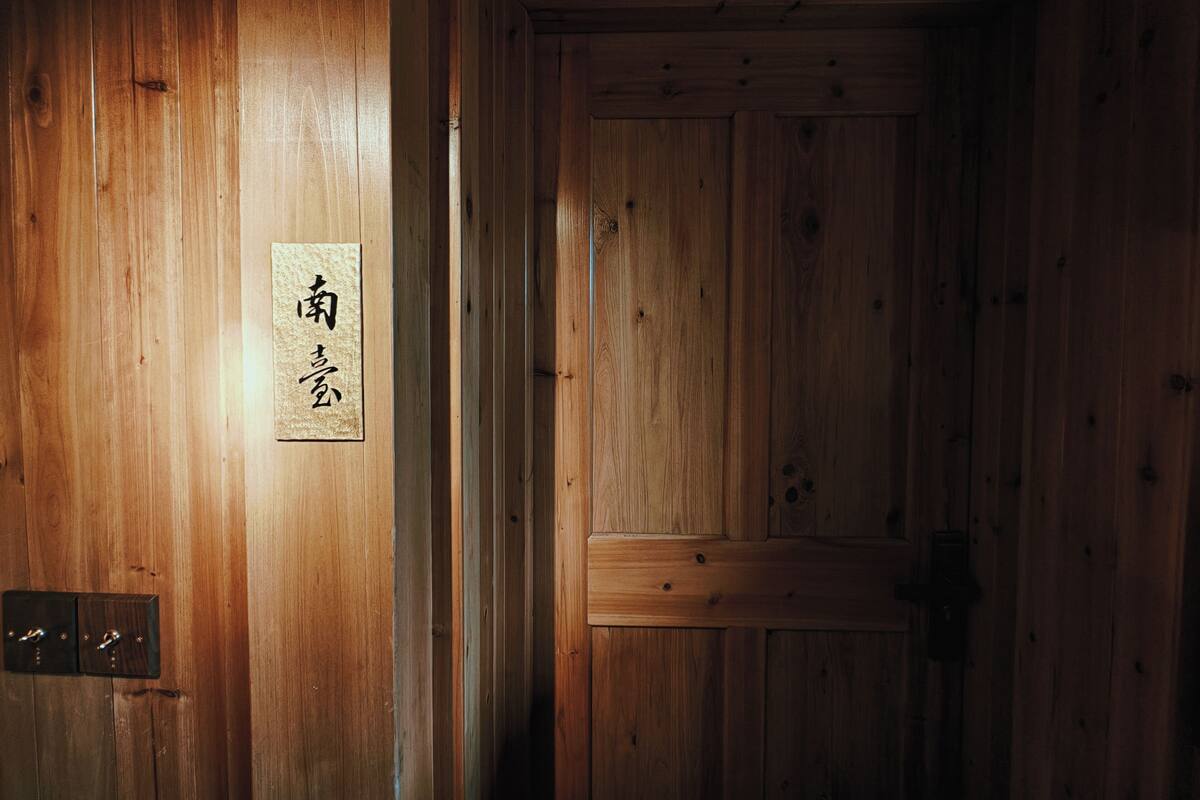 Una puerta de madera con un letrero que dice '南' y '北'.