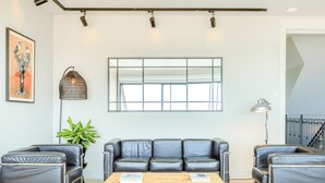 Ein modernes Wohnzimmer mit einem Ledersofa, einem Holztisch und einem großen Fenster.
