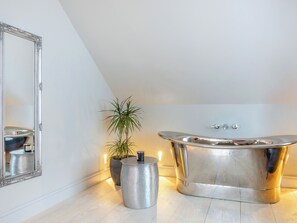 A modern bathroom with a freestanding bathtub, a large mirror, and a potted plant. - 2 bedroom accommodation in Saunton and Braunton (Saunton and Braunton)