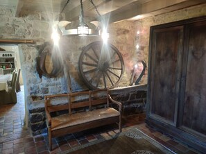 A rustic interior with a stone wall, wooden bench, and large wheels. - Very large farmhouse in a quiet hamlet near Auray and Carnac. (Ploemel)