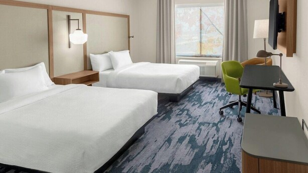A hotel room with two beds, a desk, a chair, a TV, and a window with curtains. - Fairfield by Marriott Inn & Suites Norwalk (Norwalk)