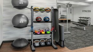 A gym with weightlifting equipment, including kettlebells, medicine balls, and dumbbells. - Fairfield by Marriott Inn & Suites Norwalk (Norwalk)