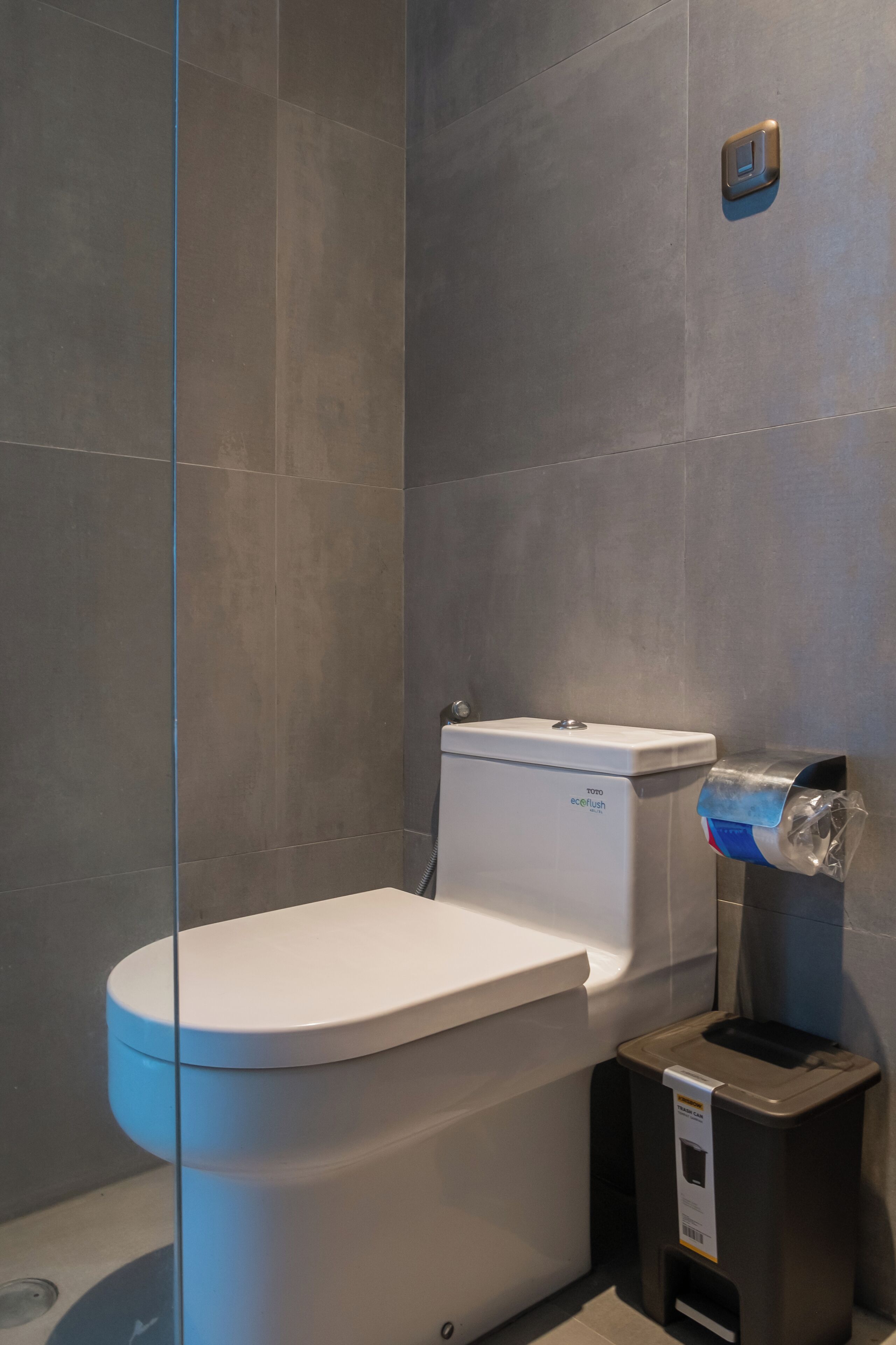 Un baño moderno con inodoro, bidé y cubo de basura.